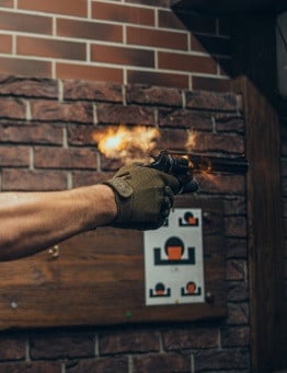 dłonie ze strzelającym pistoletem
